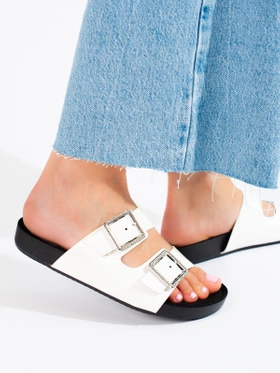 White slip-on sandals with decorative buckles